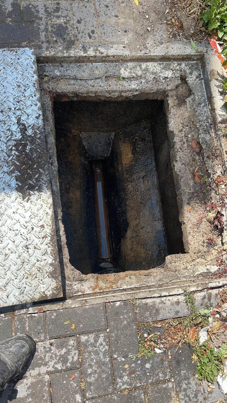 Exposed drainage channel inside an open inspection chamber.