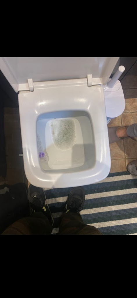 Square toilet bowl photographed during blocked toilet work in Enfield