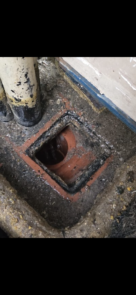 Open clay drain access beside pipework in Milton Keynes